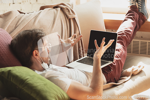 Image of Young man studying at home during online courses for journalist, critics, writers