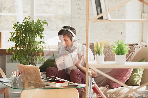 Image of Young man studying at home during online courses for marketer, architect, translator