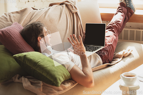 Image of Young man studying at home during online courses for journalist, critics, writers
