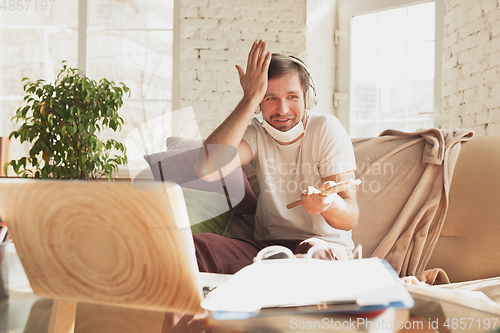 Image of Young man studying at home during online courses for musician, drummer, producer