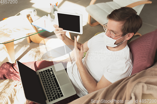 Image of Young man studying at home during online courses for disinfector, nurse, medical services