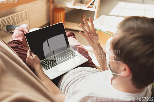 Image of Young man studying at home during online courses for disinfector, nurse, medical services