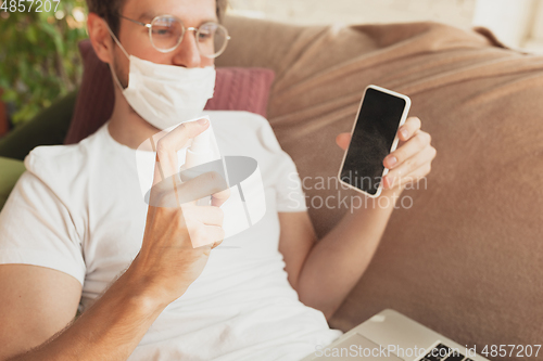 Image of Young man studying at home during online courses for disinfector, nurse, medical services