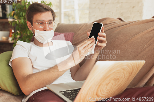 Image of Young man studying at home during online courses for disinfector, nurse, medical services