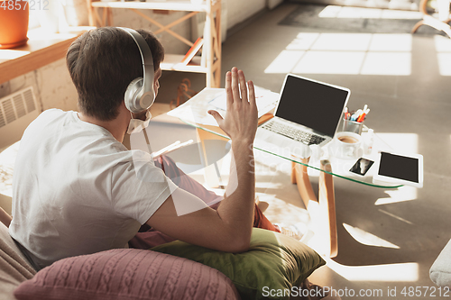 Image of Young man studying at home during online courses for musician, drummer, producer