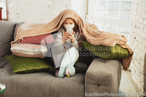 Image of Little girl in protective mask isolated at home with coronavirus symptoms, stop epidemic