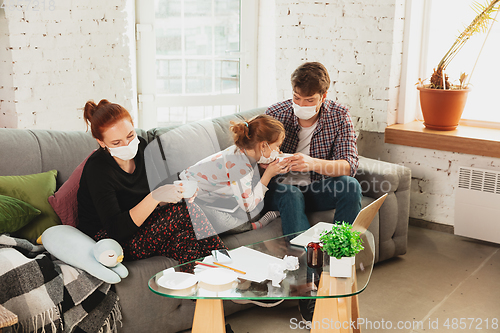 Image of Caucasian family in protective masks and gloves isolated at home with coronavirus symptoms, stop epidemic