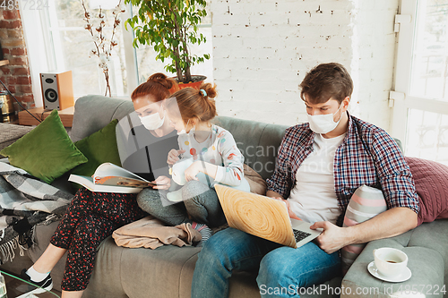 Image of Caucasian family in protective masks and gloves isolated at home with coronavirus symptoms, treatment