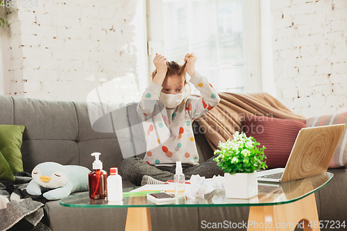 Image of Little girl in protective mask isolated at home with coronavirus symptoms, stop epidemic