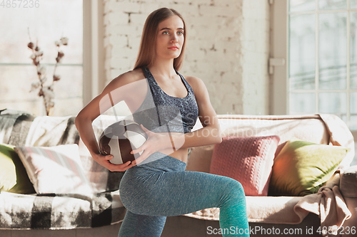 Image of Young woman teaching at home online courses of fitness, aerobic, sporty lifestyle while being quarantine