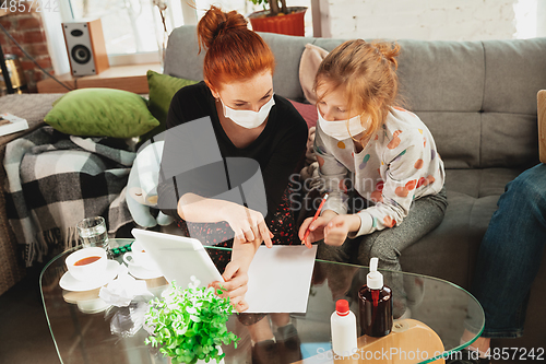 Image of Mother and daughter in protective masks and gloves isolated at home with coronavirus symptoms, stop epidemic
