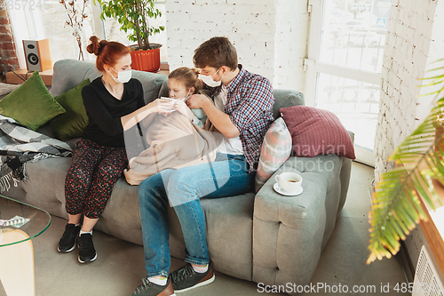 Image of Caucasian family in protective masks and gloves isolated at home with coronavirus symptoms, treatment