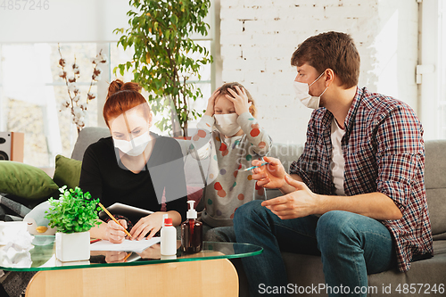 Image of Caucasian family in protective masks and gloves isolated at home with coronavirus symptoms, treatment