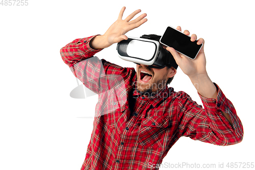 Image of Man emotional playing, using virtual reality headset isolated on white studio background