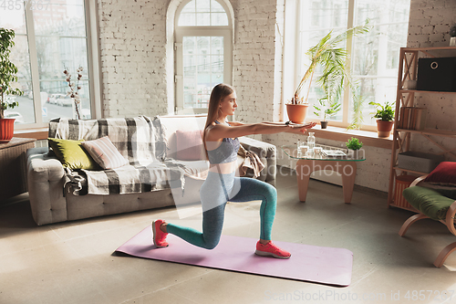 Image of Young woman teaching at home online courses of fitness, aerobic, sporty lifestyle while being quarantine