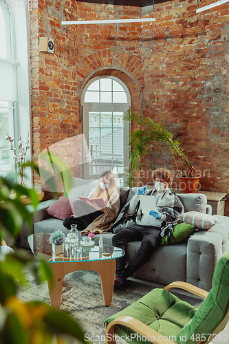 Image of Woman and man, couple in protective masks and gloves isolated at home with coronavirus symptoms