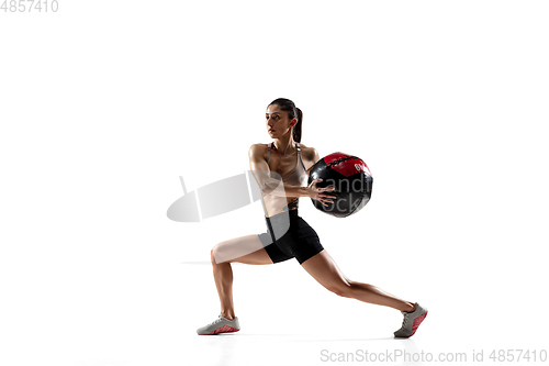 Image of Caucasian professional female athlete training isolated on white studio background. Muscular, sportive woman.