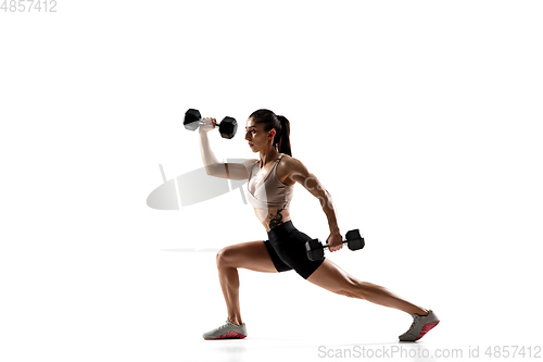 Image of Caucasian professional female athlete training isolated on white studio background. Muscular, sportive woman.