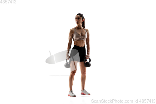 Image of Caucasian professional female athlete training isolated on white studio background. Muscular, sportive woman.