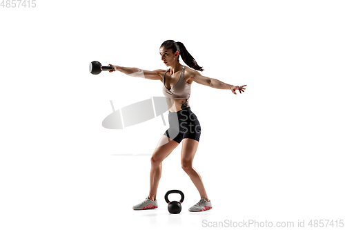 Image of Caucasian professional female athlete training isolated on white studio background. Muscular, sportive woman.