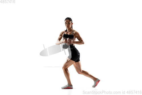 Image of Caucasian professional female athlete training isolated on white studio background. Muscular, sportive woman.