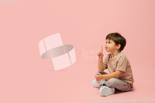 Image of Happy caucasian little boy isolated on pink studio background. Looks happy, cheerful, sincere. Copyspace. Childhood, education, emotions concept