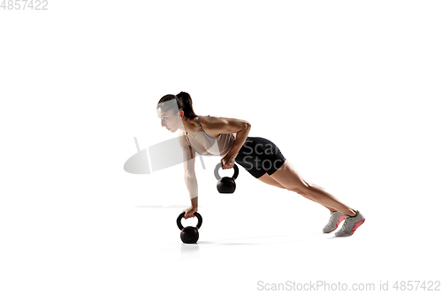 Image of Caucasian professional female athlete training isolated on white studio background. Muscular, sportive woman.