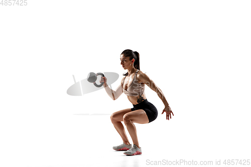 Image of Caucasian professional female athlete training isolated on white studio background. Muscular, sportive woman.