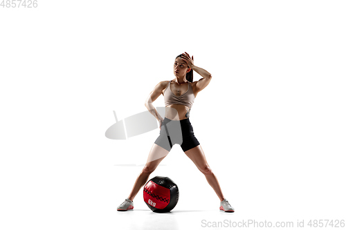 Image of Caucasian professional female athlete training isolated on white studio background. Muscular, sportive woman.