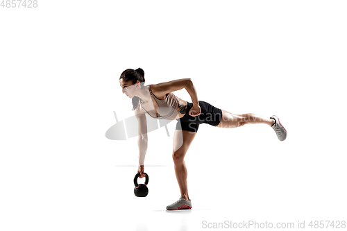 Image of Caucasian professional female athlete training isolated on white studio background. Muscular, sportive woman.