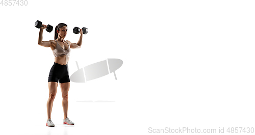 Image of Caucasian professional female athlete training isolated on white studio background. Muscular, sportive woman.