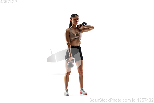 Image of Caucasian professional female athlete training isolated on white studio background. Muscular, sportive woman.