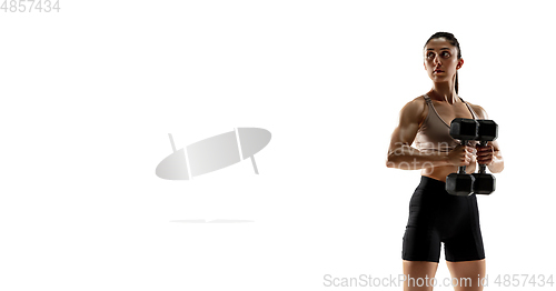 Image of Caucasian professional female athlete training isolated on white studio background. Muscular, sportive woman.