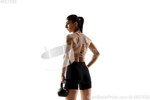 Image of Caucasian professional female athlete training isolated on white studio background. Muscular, sportive woman.