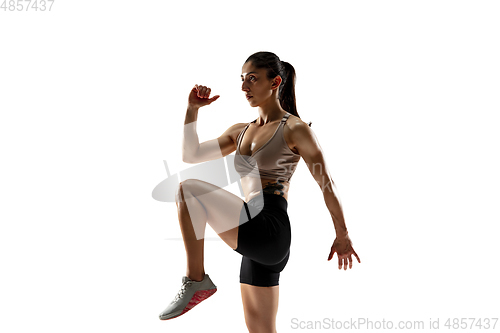 Image of Caucasian professional female athlete training isolated on white studio background. Muscular, sportive woman.