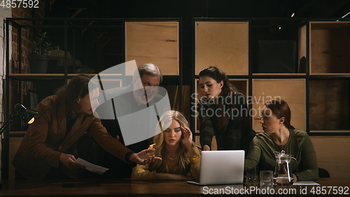 Image of Young colleagues working together in a office styled like classical artworks. Look busy, attented, cheerful, successful. Concept of business, office, finance.