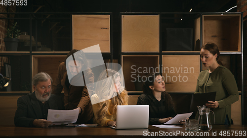 Image of Young colleagues working together in a office styled like classical artworks. Look busy, attented, cheerful, successful. Concept of business, office, finance.