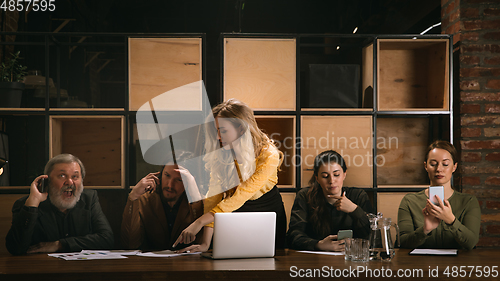 Image of Young colleagues working together in a office styled like classical artworks. Look busy, attented, cheerful, successful. Concept of business, office, finance.