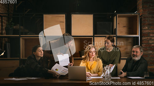 Image of Young colleagues working together in a office styled like classical artworks. Look busy, attented, cheerful, successful. Concept of business, office, finance.