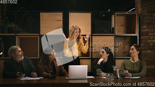 Image of Young colleagues working together in a office styled like classical artworks. Look busy, attented, cheerful, successful. Concept of business, office, finance.