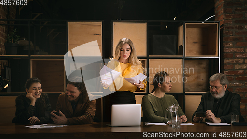 Image of Young colleagues working together in a office styled like classical artworks. Look busy, attented, cheerful, successful. Concept of business, office, finance.