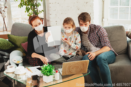 Image of Caucasian family in protective masks and gloves isolated at home with coronavirus symptoms, treatment