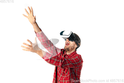 Image of Man emotional playing, using virtual reality headset isolated on white studio background