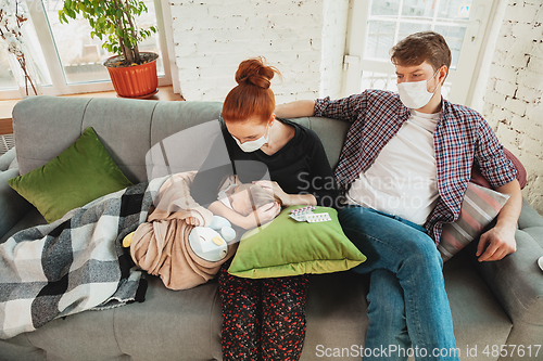 Image of Caucasian family in protective masks and gloves isolated at home with coronavirus symptoms, treatment