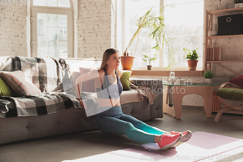 Image of Young woman teaching at home online courses of fitness, aerobic, sporty lifestyle while being quarantine