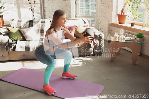 Image of Young woman teaching at home online courses of fitness, aerobic, sporty lifestyle while being quarantine