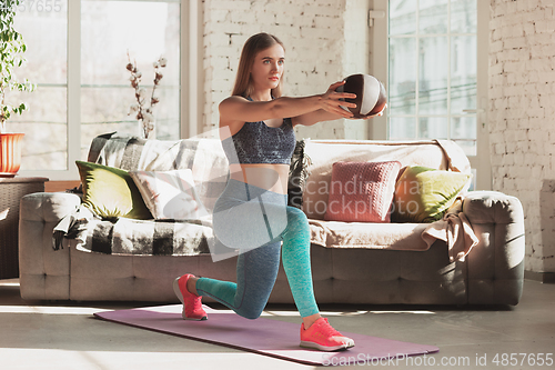 Image of Young woman teaching at home online courses of fitness, aerobic, sporty lifestyle while being quarantine
