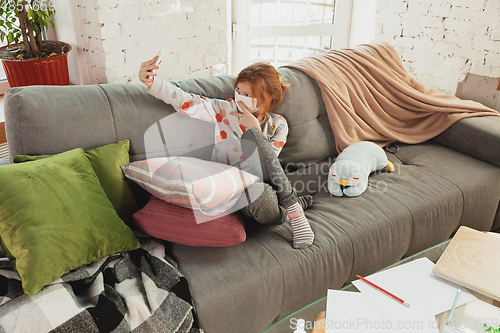 Image of Little girl in protective mask isolated at home with coronavirus symptoms, stop epidemic