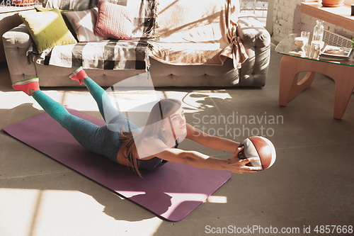 Image of Young woman teaching at home online courses of fitness, aerobic, sporty lifestyle while being quarantine