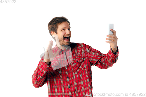 Image of Emotional caucasian man using smartphone isolated on white studio background